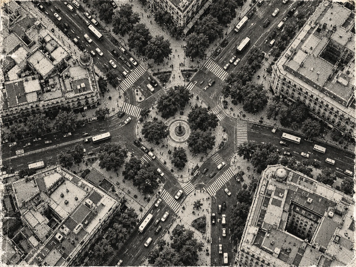Monochrome satellite-style view of a dense city intersection with crossings and trees